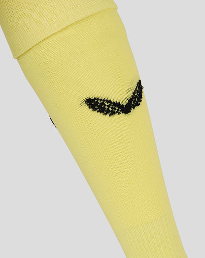 Close-up of yellow MK Dons junior goalkeeper away sock with a black logo.