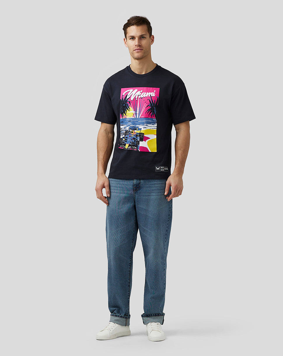 Full body of a male model in a navy Miami graphic oversized T shirt paired with blue jeans.