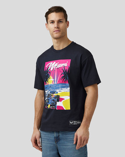 Front view of a man wearing navy Miami oversized T shirt with a bright retro graphic of palm trees sunset and a race car.