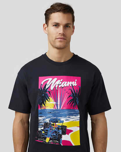 Male model wearing navy oversized Miami graphic T-shirt with pink sunset and race car print