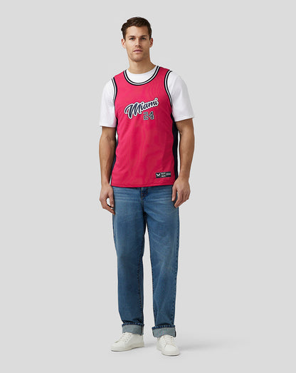 Man wearing bright pink Miami basketball jersey with white sleeves and Miami 24 on the chest