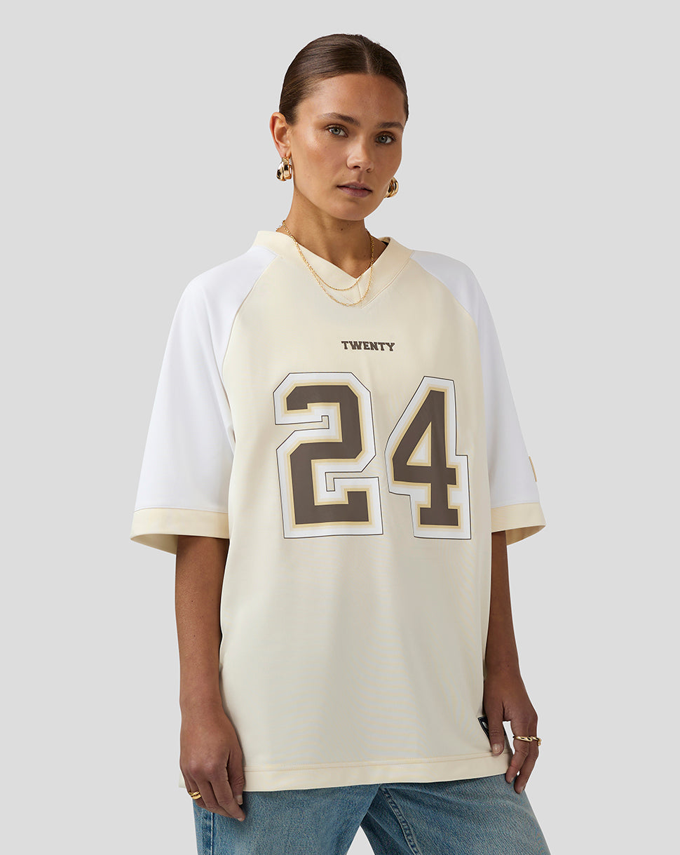 Female model wearing cream and white Twenty 24 football jersey with bold front numbers.