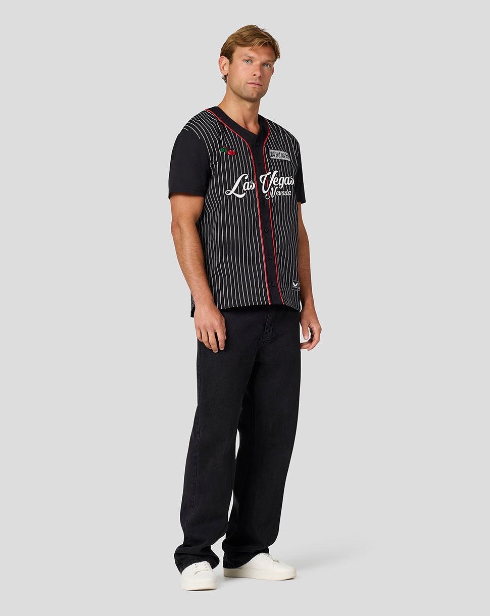 Model wearing Oracle Red Bull Racing Las Vegas baseball jersey with black base white pinstripes and red trim.