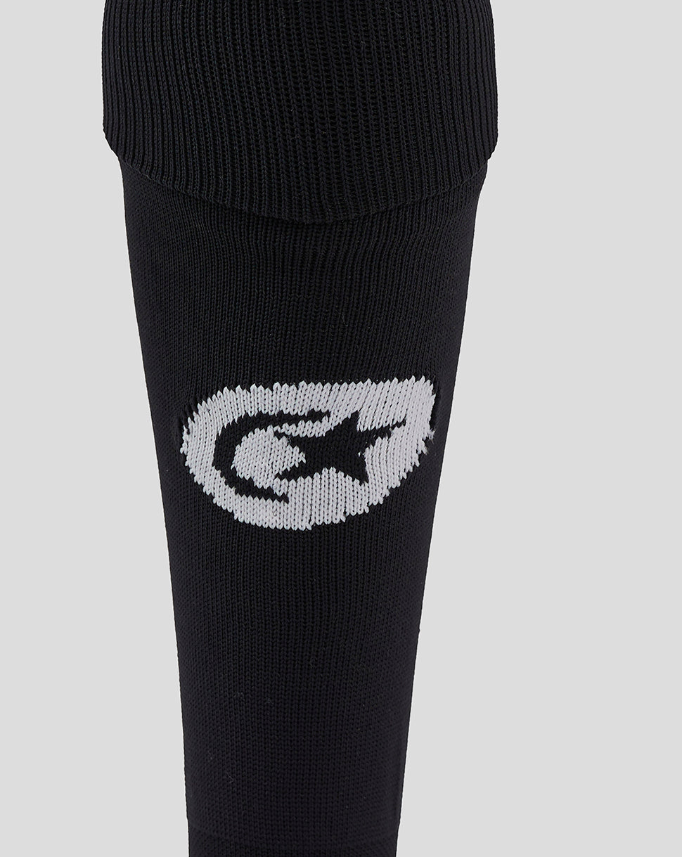 Close-up of the black sock showing a white stitched Saracens emblem on the calf area