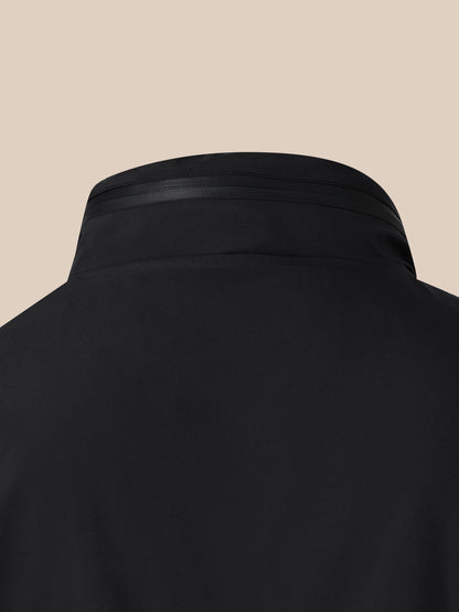 Close up of black waterproof jacket hood showing stitching and zipper against a tan background