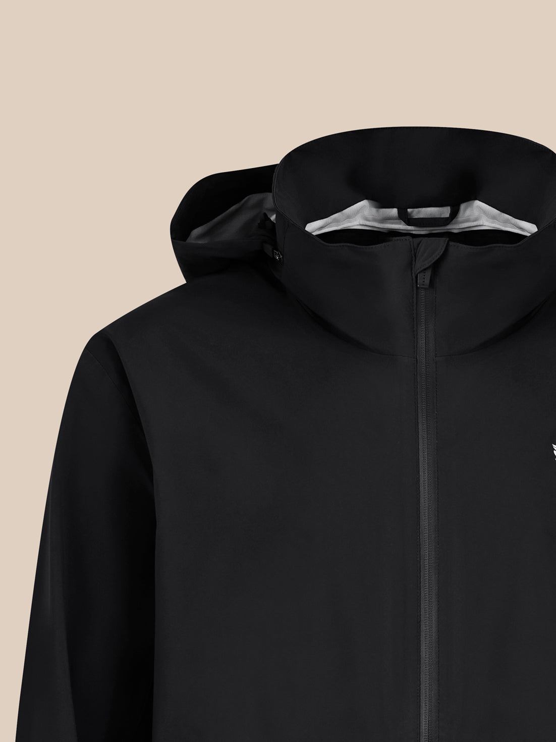 Close up of hooded black waterproof jacket showing front zipper and subtle logo on chest