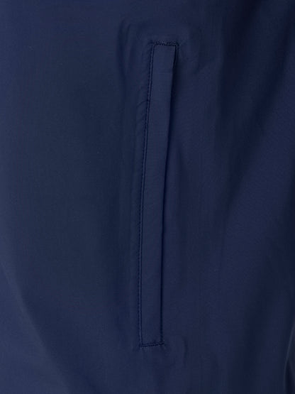Close up of navy waterproof jacket fabric showing a vertical pocket opening with reinforced seam
