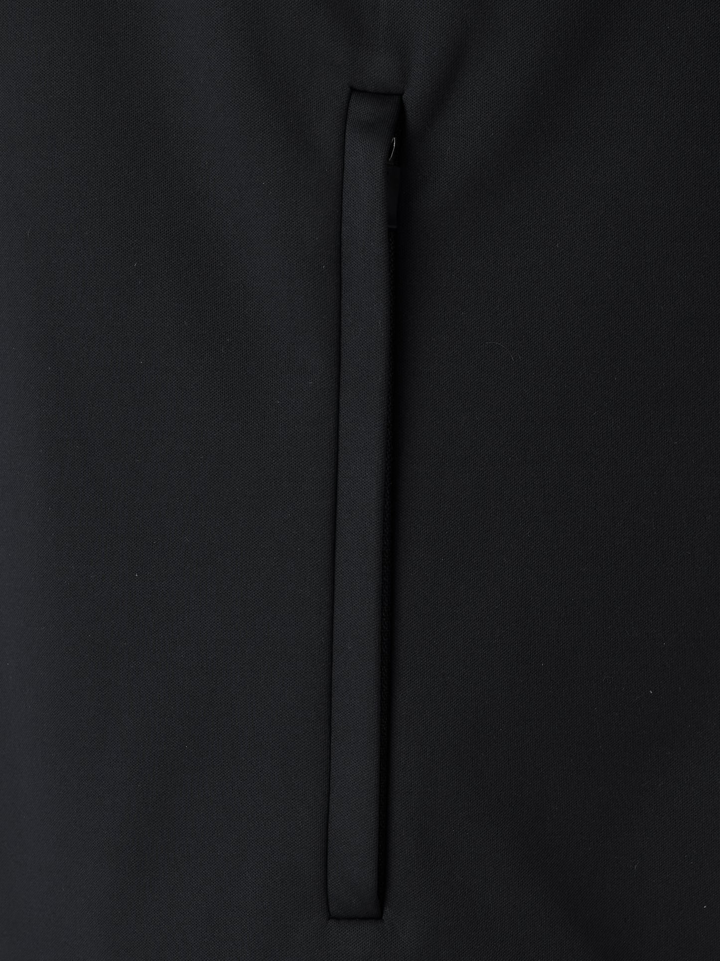 Close-up of black softshell jacket fabric with a vertical zipper