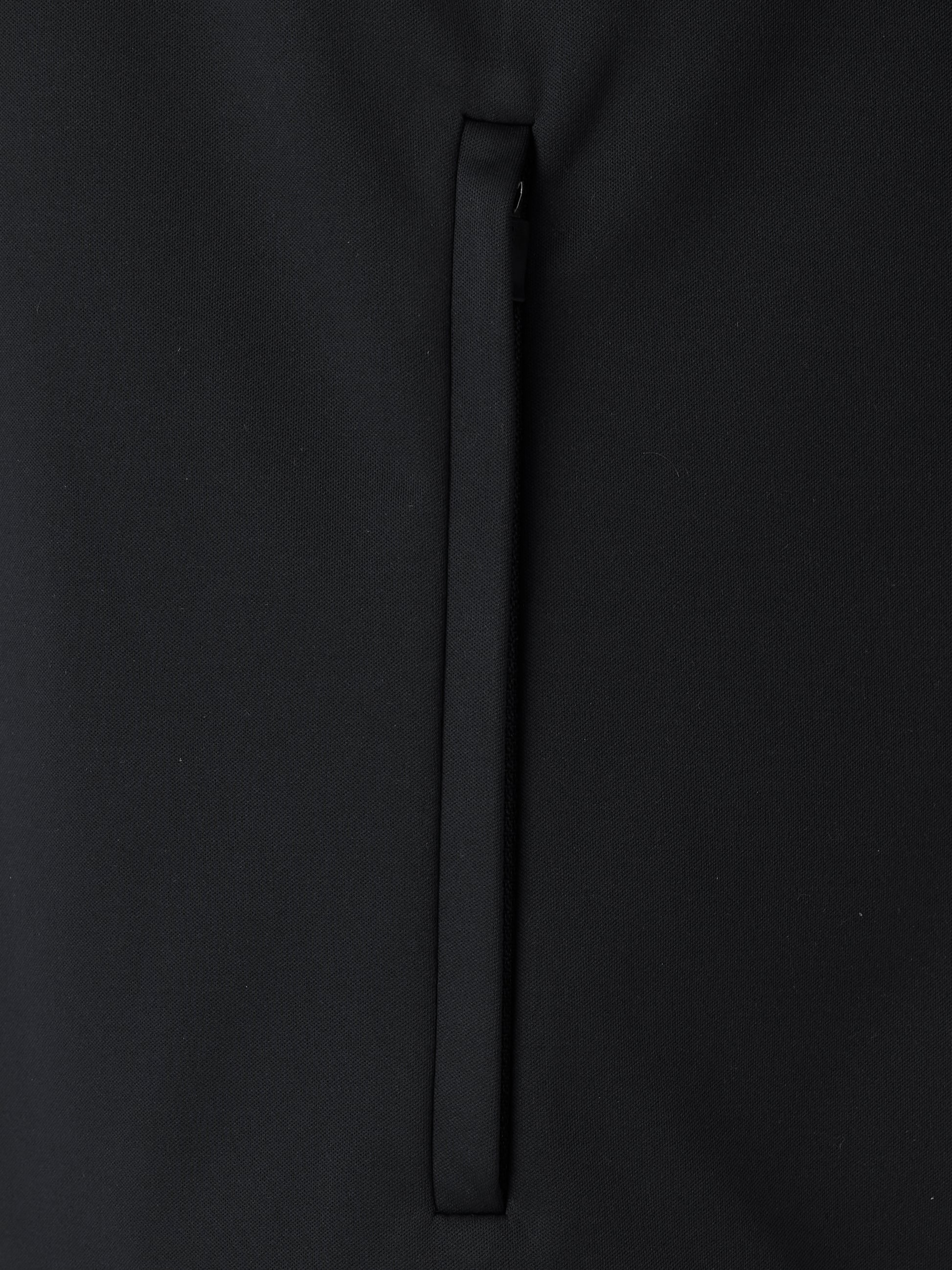 Close-up of black softshell jacket fabric with a vertical zipper