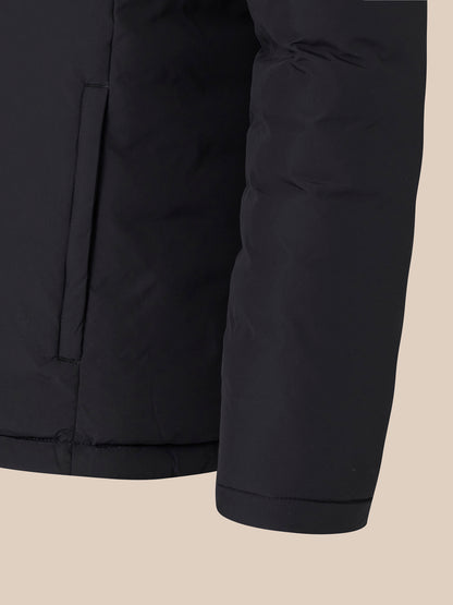 Close-up of black padded jacket showing zip pocket and matte fabric