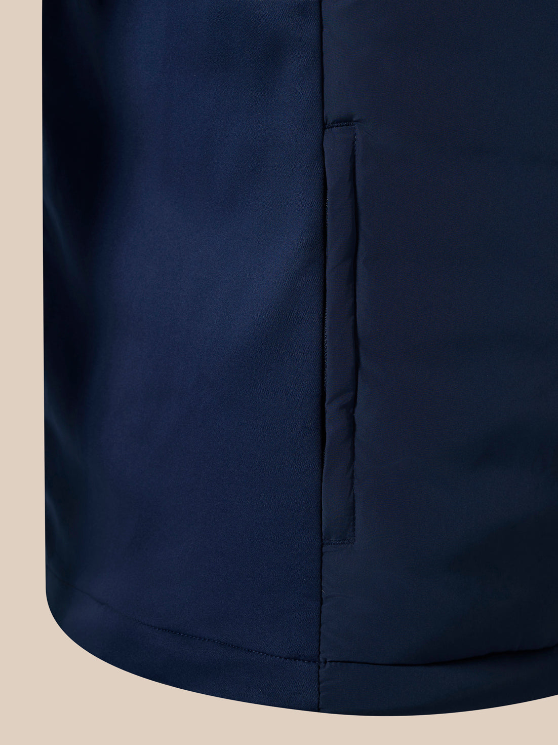 Close-up of navy padded gilet showing vertical zipper along the side
