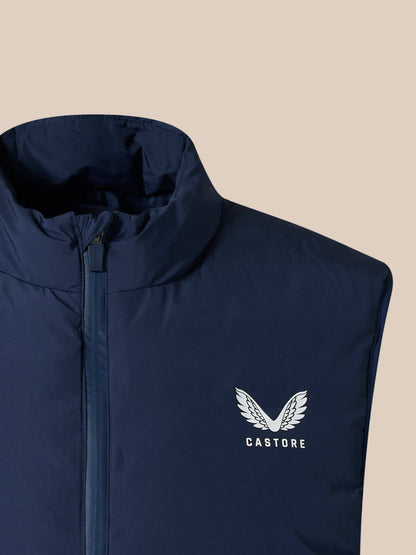 Navy padded unisex gilet with high collar and front zipper, Castore logo visible on the lower front.