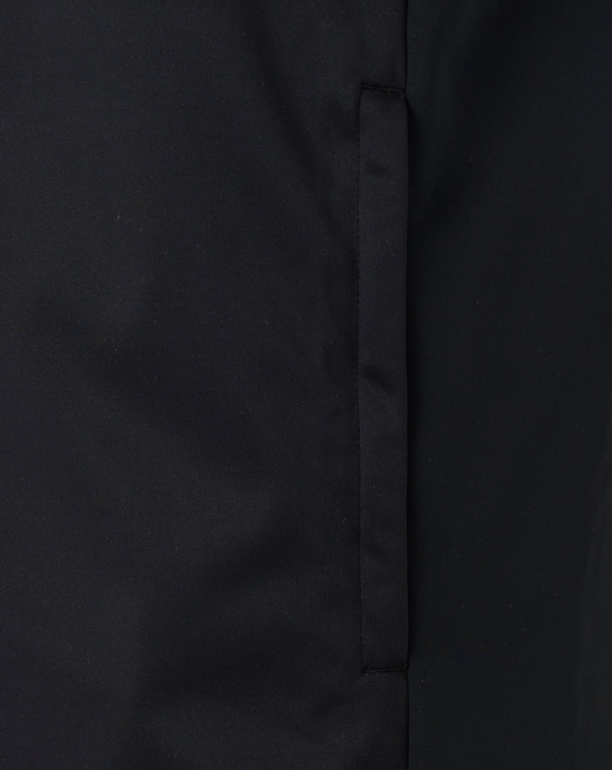 Close-up of black fabric showing front zip and seam detail on the softshell gilet.