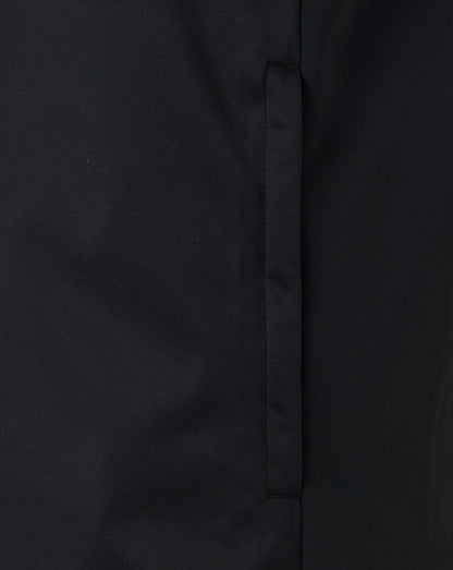 Close-up of black fabric showing front zip and seam detail on the softshell gilet.