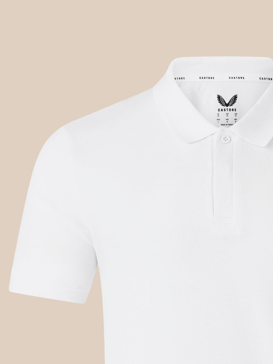 Close up of white polo shirt collar with CASTORE logo on the chest