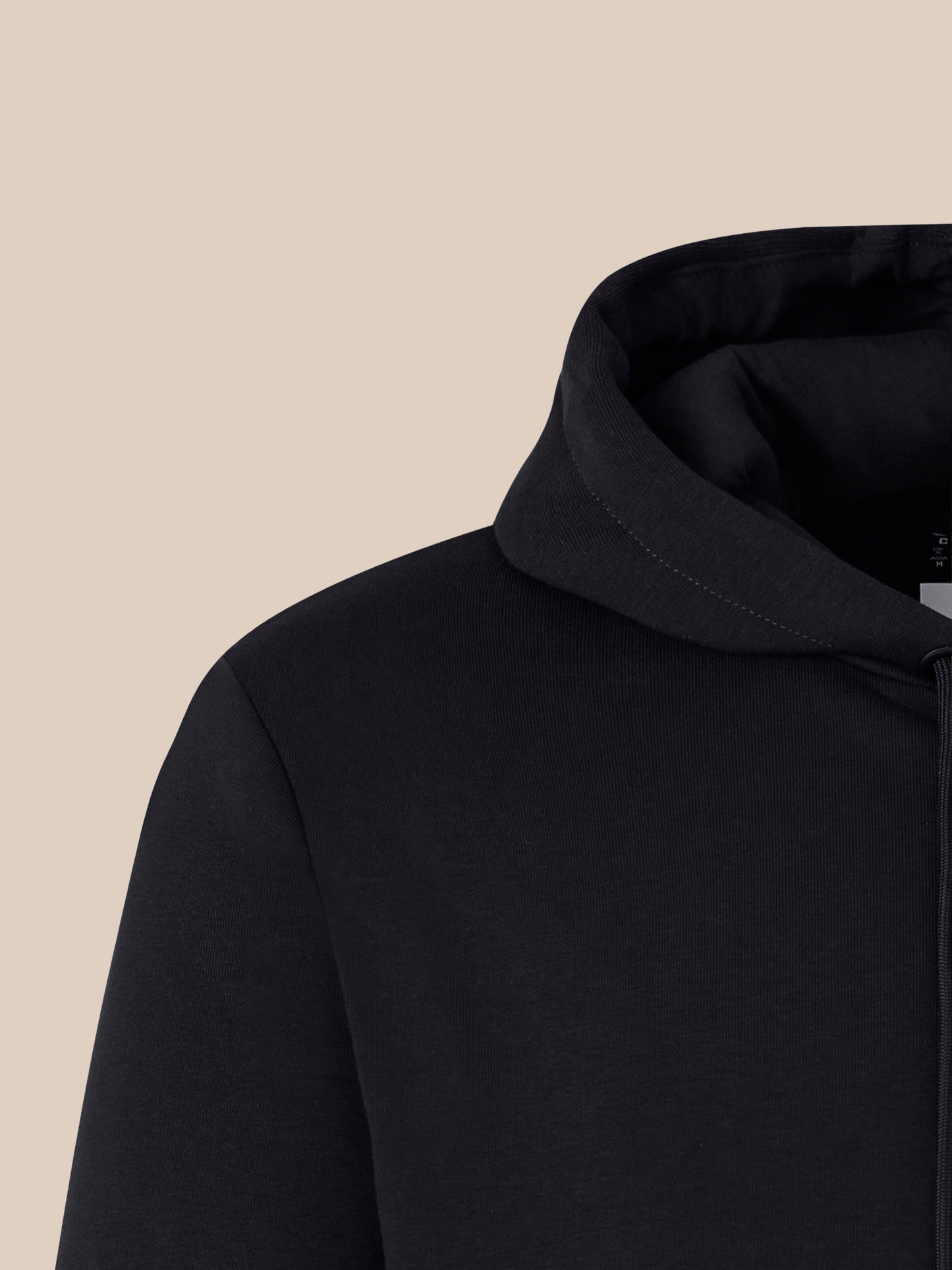 Close-up of black hoodie neckline showing stitching and a visible care tag