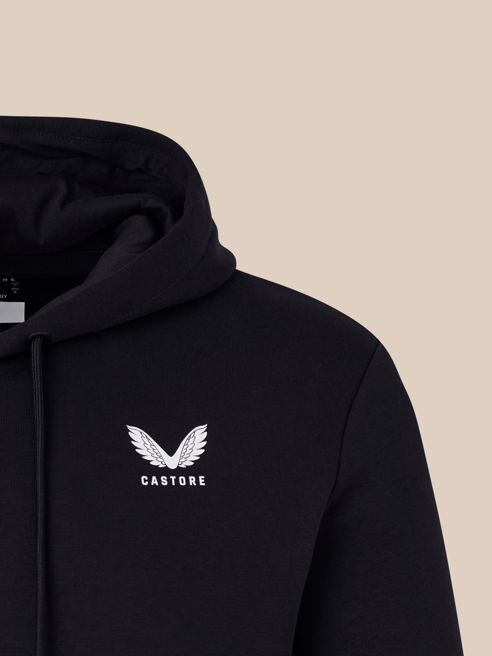 Close-up of a black lifestyle hoodie hood against a beige background