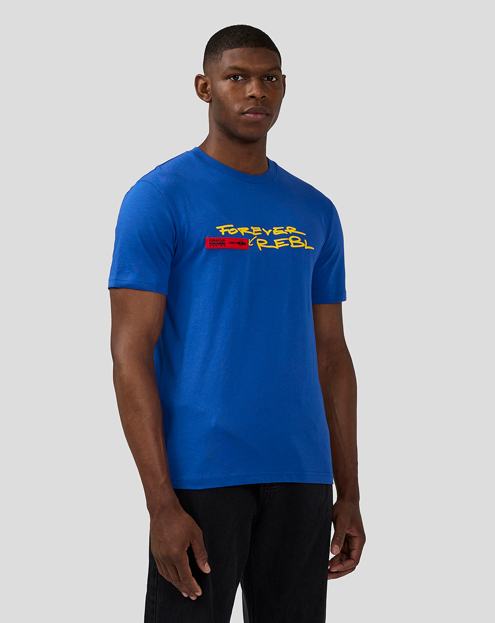 Front view of a male model wearing a blue T shirt featuring the Forever Rebel graphic and red chest patch.