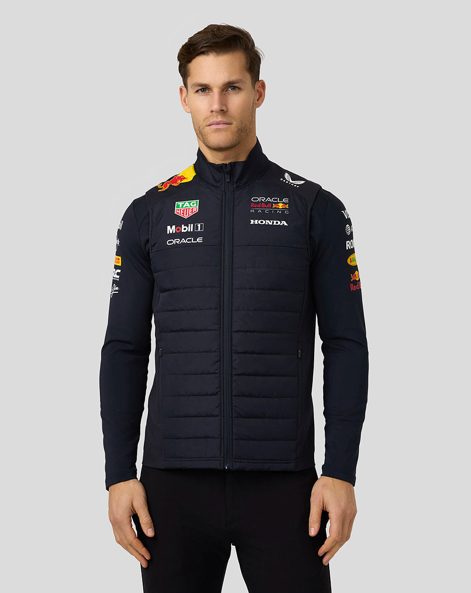 Male model in navy teamline hybrid gilet with padded front and sponsor branding for a sleek sleeveless look.