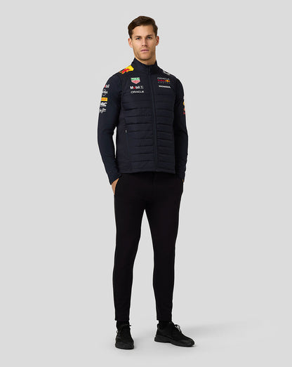 Full body front view of model in navy padded jacket with team branding and sponsor logos