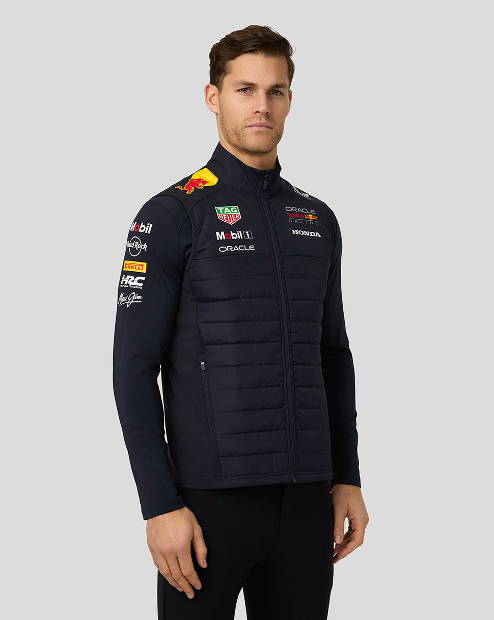 Male model in navy teamline hybrid gilet with zip front funnel neckline and sponsor logos.