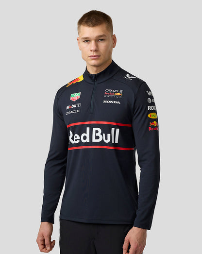 Male model wearing navy Oracle Red Bull Racing 1/4 zip midlayer with Red Bull graphic and sponsor logos.