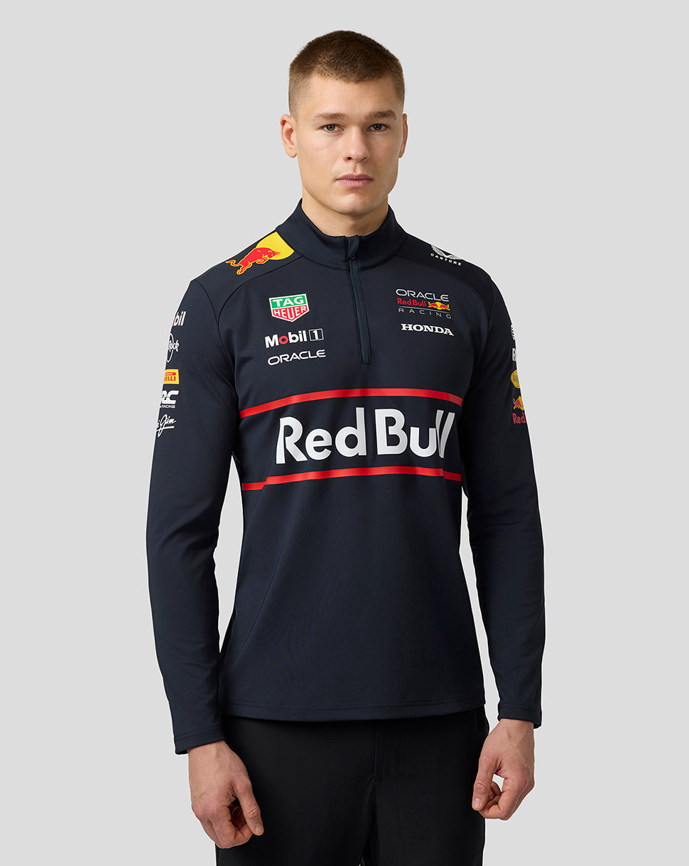 Front view of a male model wearing a navy Red Bull Racing team midlayer with large Red Bull chest logo and sponsor patches.