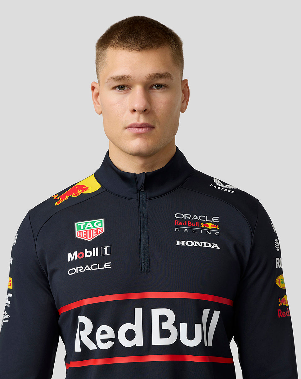 Close up of a male model wearing the navy quarter zip midlayer with Red Bull branding on chest and shoulders.