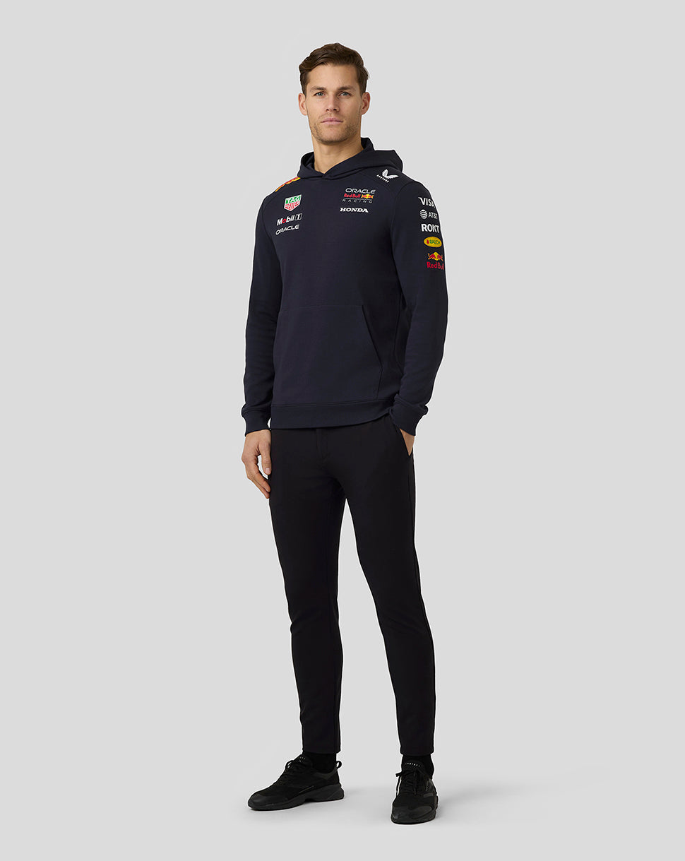 Full view of a man in a navy Oracle Red Bull Racing hoodie with sponsor logos across the chest and sleeves.