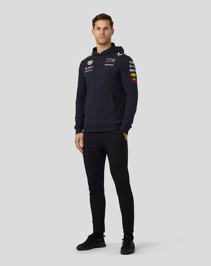 Full view of a man in a navy Oracle Red Bull Racing hoodie with sponsor logos across the chest and sleeves.