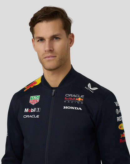 Back and side view of navy teamline bomber jacket with sponsor branding on chest and sleeve.