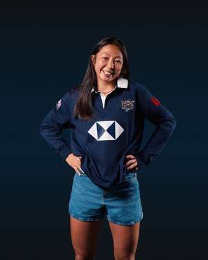Female model wearing a vintage navy long sleeve HK7s rugby jersey with crest and white geometric chest logo.