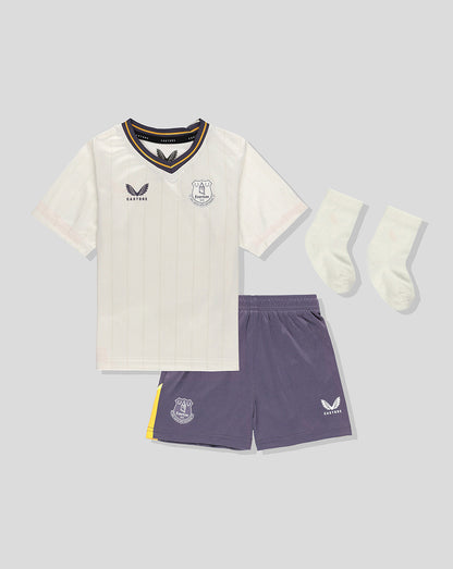 Front view of Everton 24/25 third nested baby kit featuring cream pinstriped jersey, purple shorts, and white socks