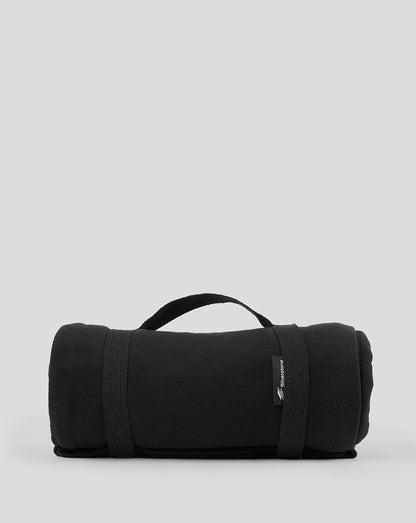Rolled Black Silverstone fleece blanket with a top carrying handle and brand tag