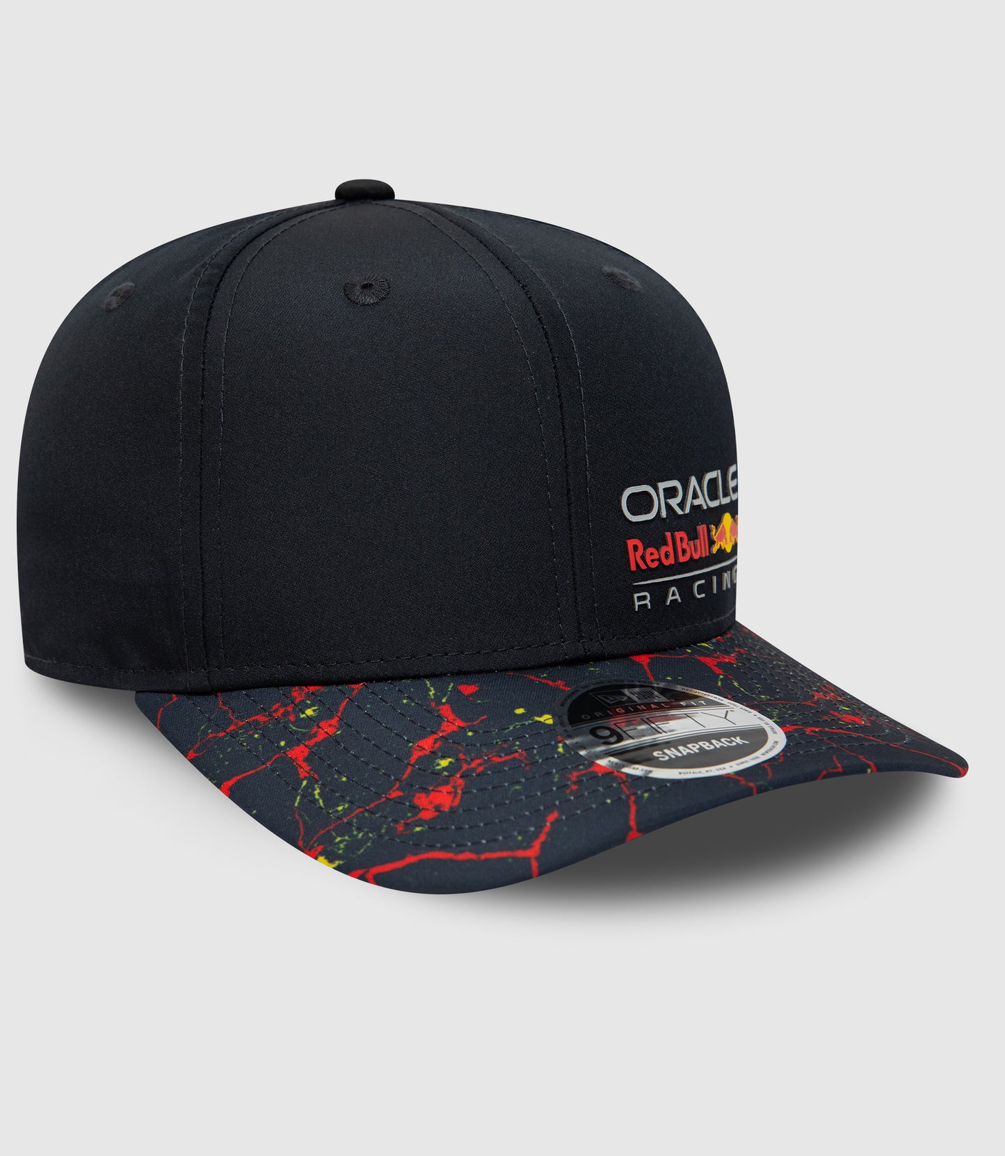 Angled view of navy New Era cap with lava splatter brim and Oracle Red Bull Racing branding on crown