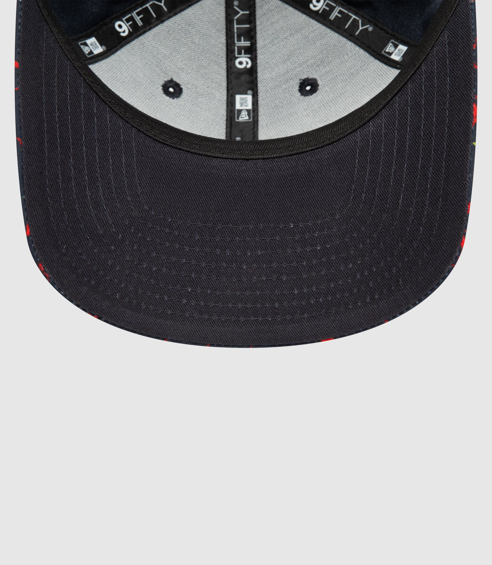 Interior view of navy New Era 9FIFTY snapback showing branded tape and adjustable rear strap