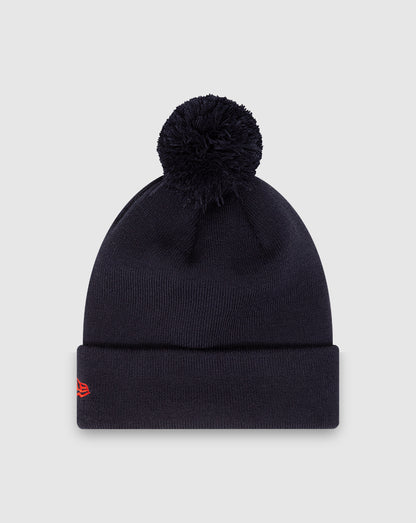 Navy knit beanie with a fluffy pom and folded cuff featuring Oracle Red Bull patch and New Era insignia