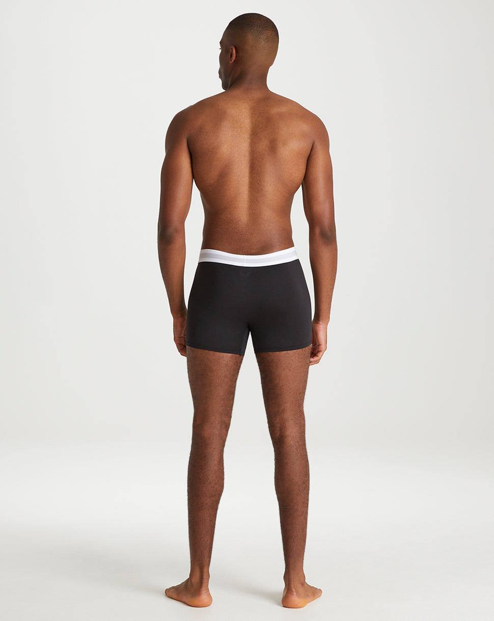 Back view of a male model wearing black Onyx boxer shorts with a white elastic waistband