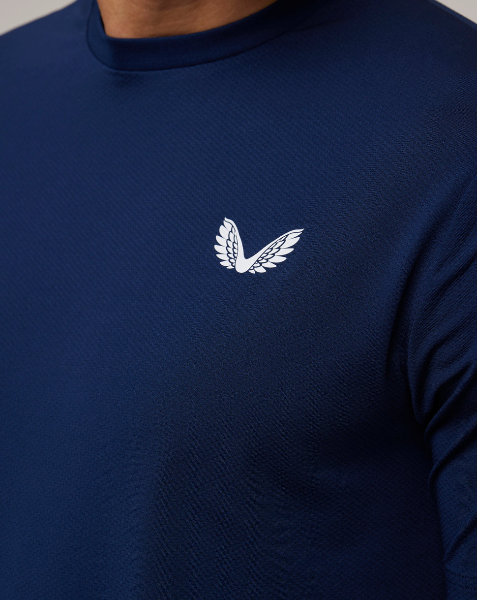 Close-up of the navy Peacoat Active 365 Tee chest area highlighting the white Castore Wings logo