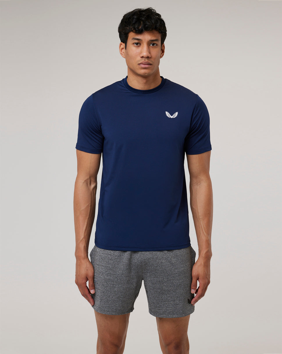 Model wearing navy Peacoat Active 365 Tee with reflective Castore Wings emblem on the chest.