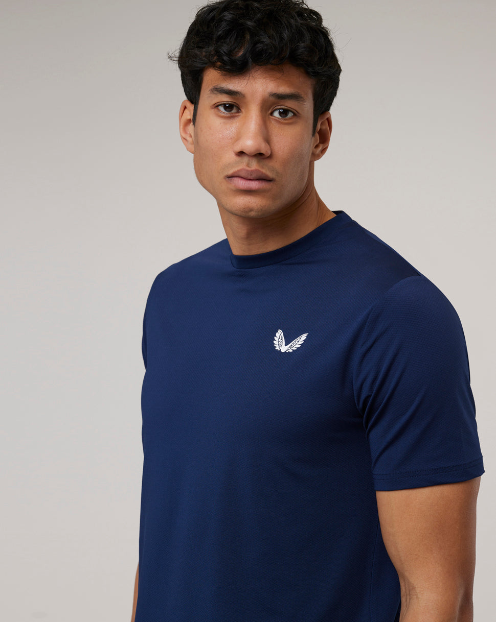 Close-up of a man in a navy Peacoat Active 365 Tee showing the white Castore Wing logo on the chest