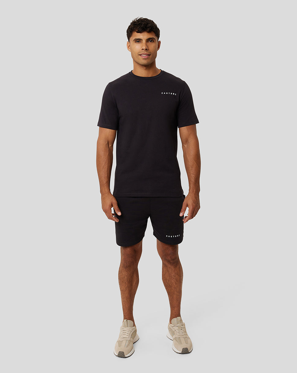 Full-length front view of a male model in black Onyx Carbon Capsule Recovery T-Shirt and matching shorts with CASTORE branding