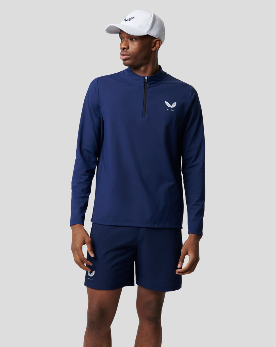 Male model in navy Peacoat Active Mid Layer 1/4 Zip top with matching shorts and white cap