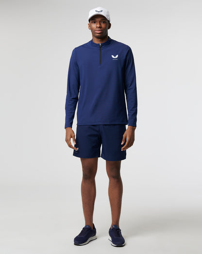 Male model wearing navy Peacoat Active mid layer 1/4 zip top during training, paired with matching shorts.