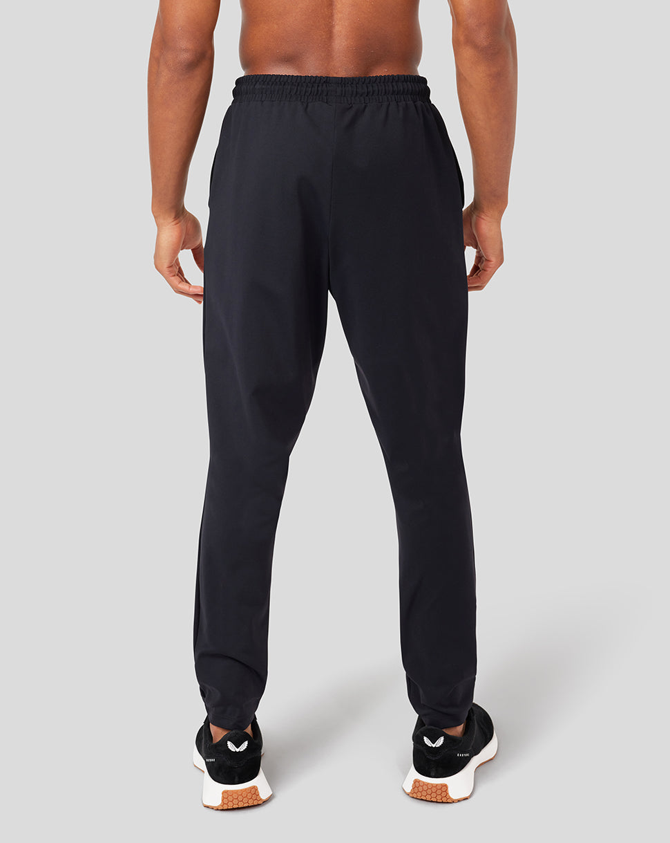 Back view of a person in black Onyx Active Slim Fit joggers with gathered waistband and tapered ankles.