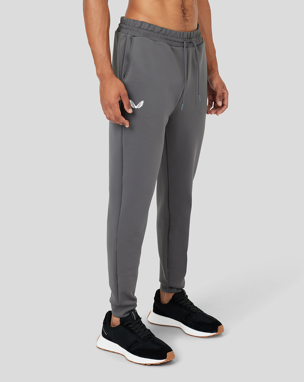 Gray Magnet Ore Capsule scuba jogger worn by a model with a white wing logo on the thigh and black sneakers