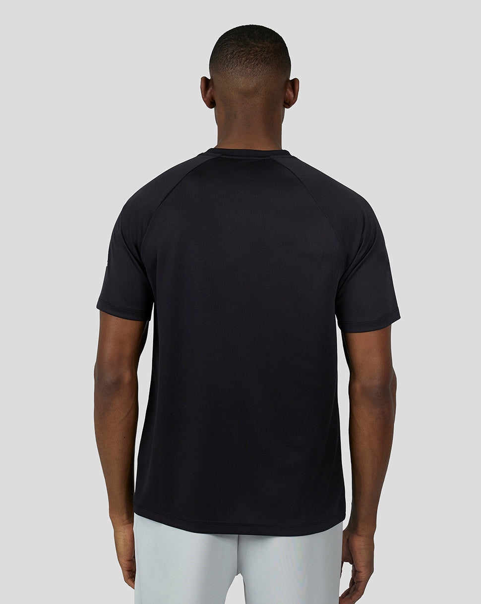Back view of a man wearing a black short sleeve raglan tee
