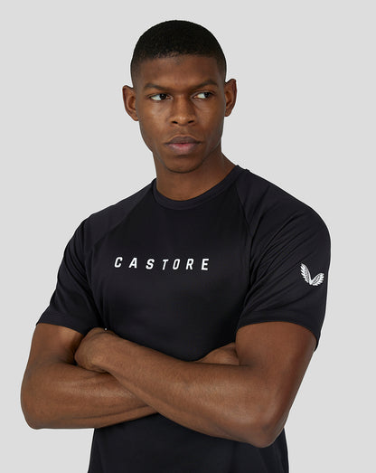 Male model wearing black Castore raglan tee featuring branding on chest and a logo on the sleeve.