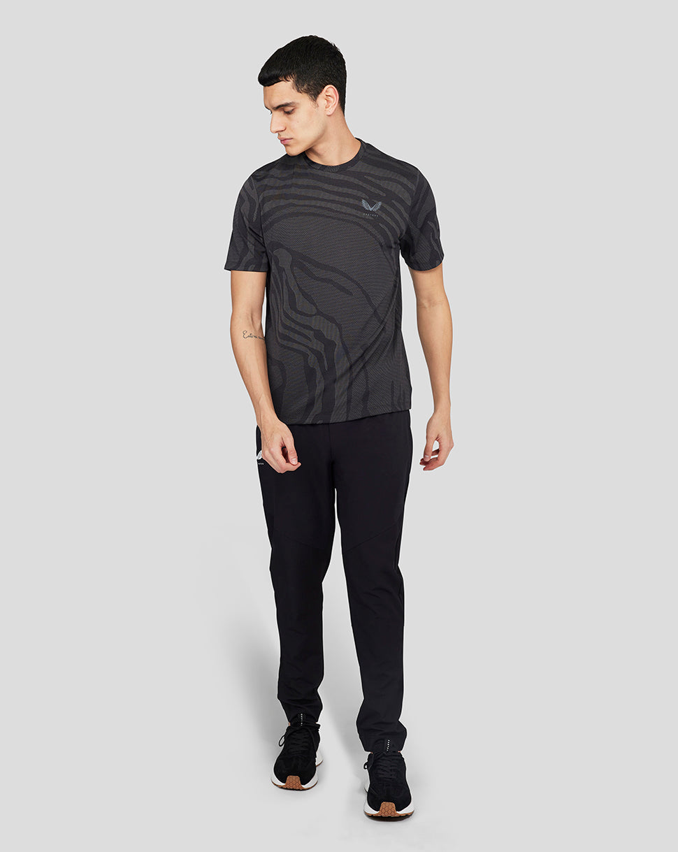 Front view of a man wearing the black Core Tech T-Shirt with a small left chest logo and bold allover pattern.