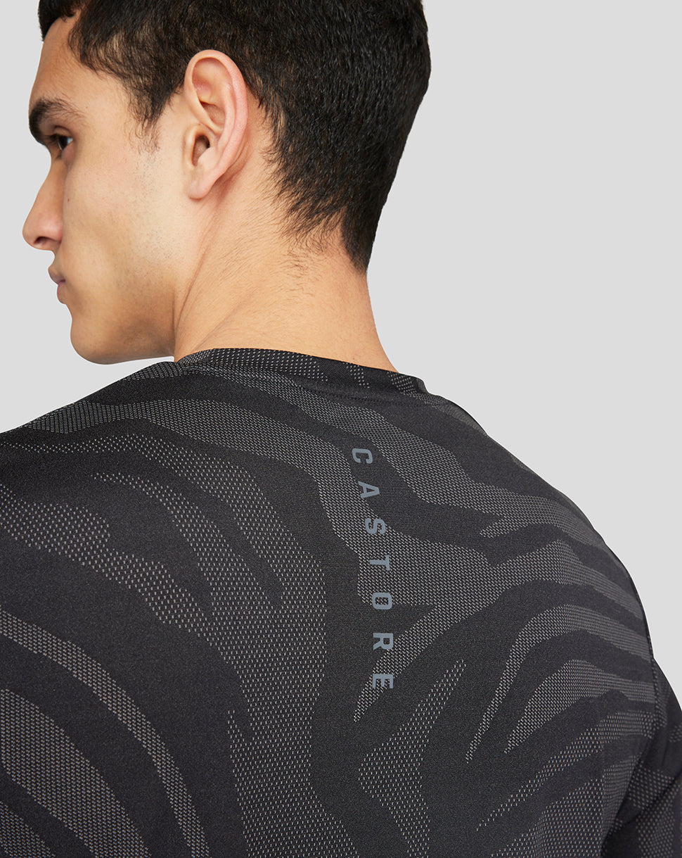 Back view of a male wearing a black Core Tech T-Shirt with a textured wavy pattern and CASTORE down the back.